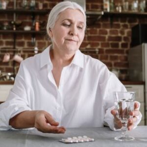 Frau nimmt Tablette ein - Medikamenten-App | Pro Aging Welt