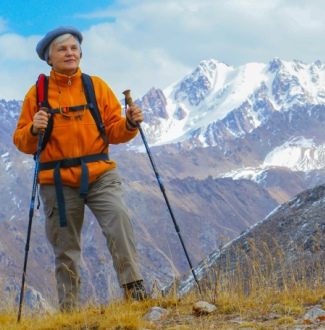 Frau wandert mit Wanderstöcken in den Bergen | Seniorensport