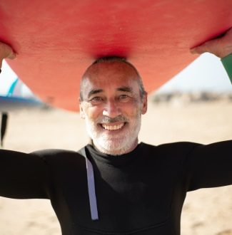 Mann mit Surfbrett | Vorbilder fürs Älterwerden